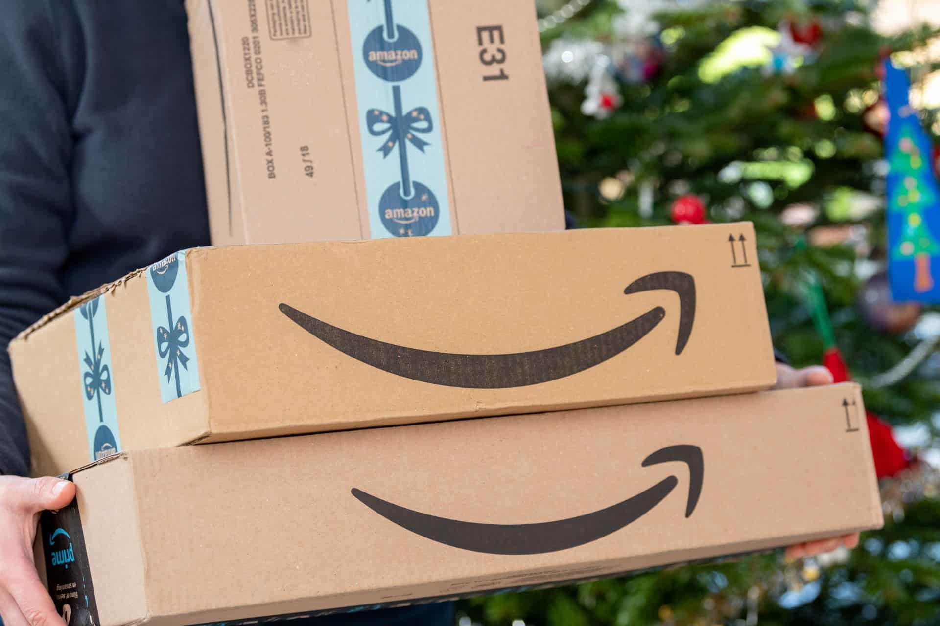 Zwei Amazon-Pakete werden von einer Person getragen, bereit zur Lieferung. Ideal für Artikel über E-Commerce und Amazon-Startups