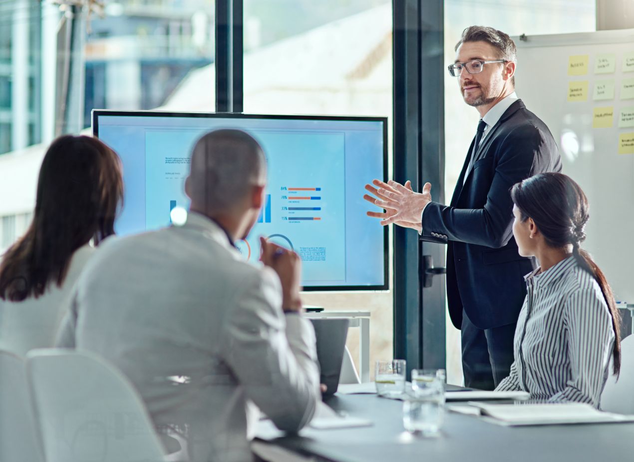 Geschaeftsleute bei Praesentation im Konferenzraum mit Fokus auf Erscheinung und Arbeitskleidung bedrucken lassen online