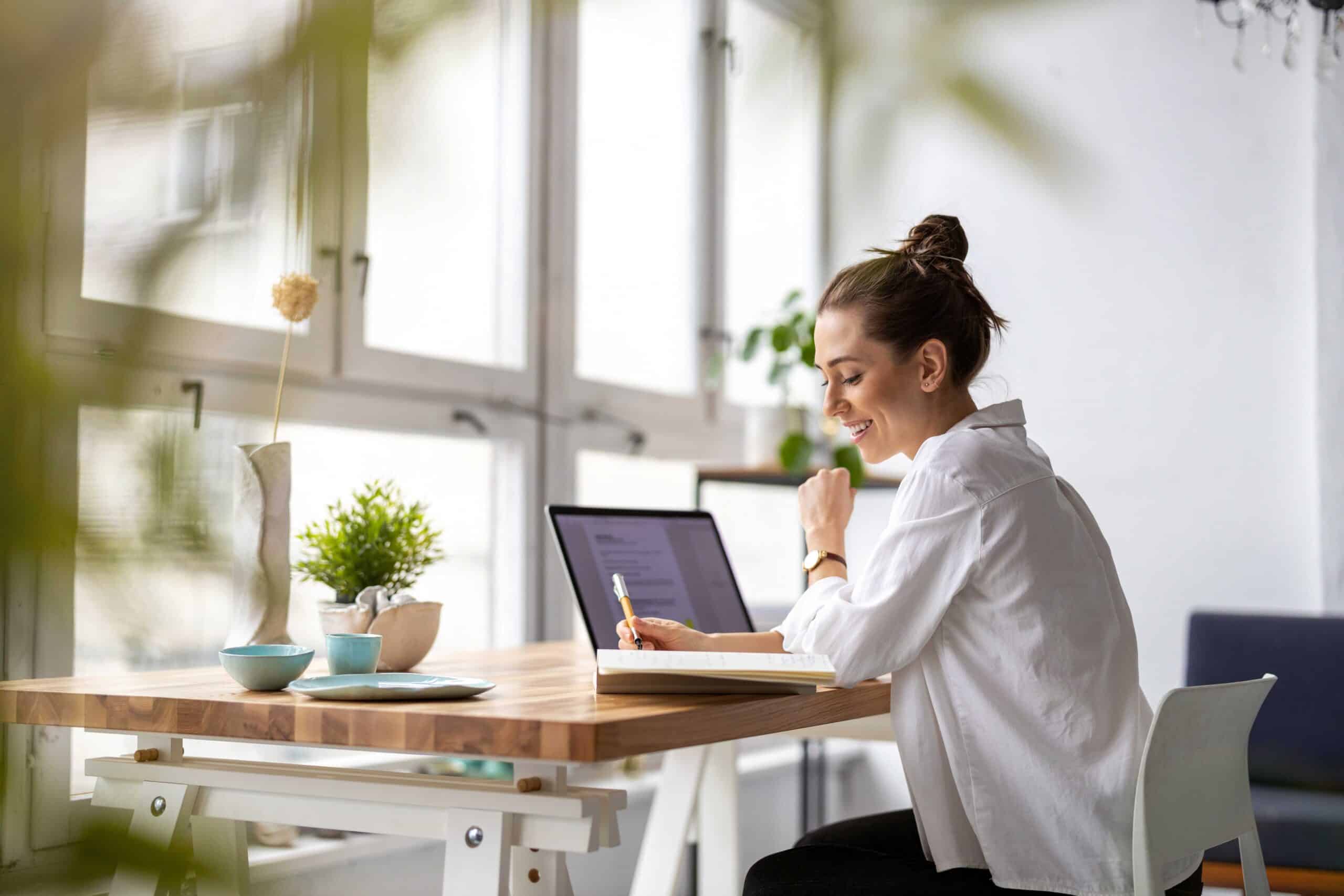 Kreative junge Frau arbeitet in ihrem Studio an ihrem Laptop