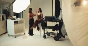 Visagistin beim Styling einer jungen Frau im Studio – Symbolbild fuer Reality-Berufe und Karriere als Escort werden