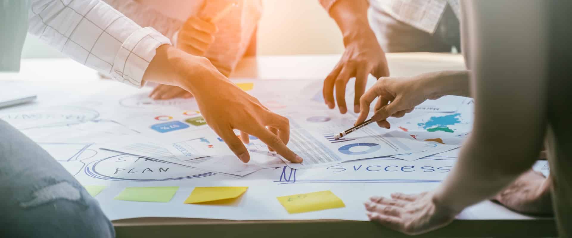 Team arbeitet gemeinsam an Strategieunterlagen | Lohnabrechnung Outsourcing